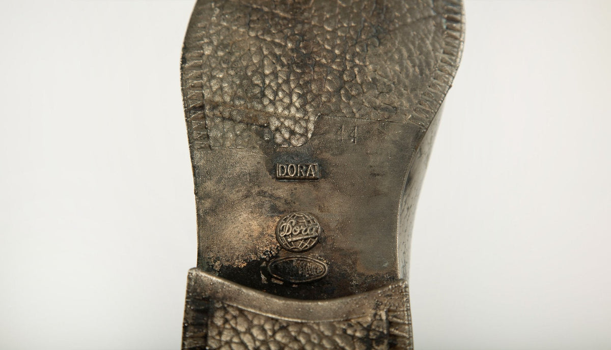 Sculpted Sole: Novelty Metal Boot with Industrial Markings